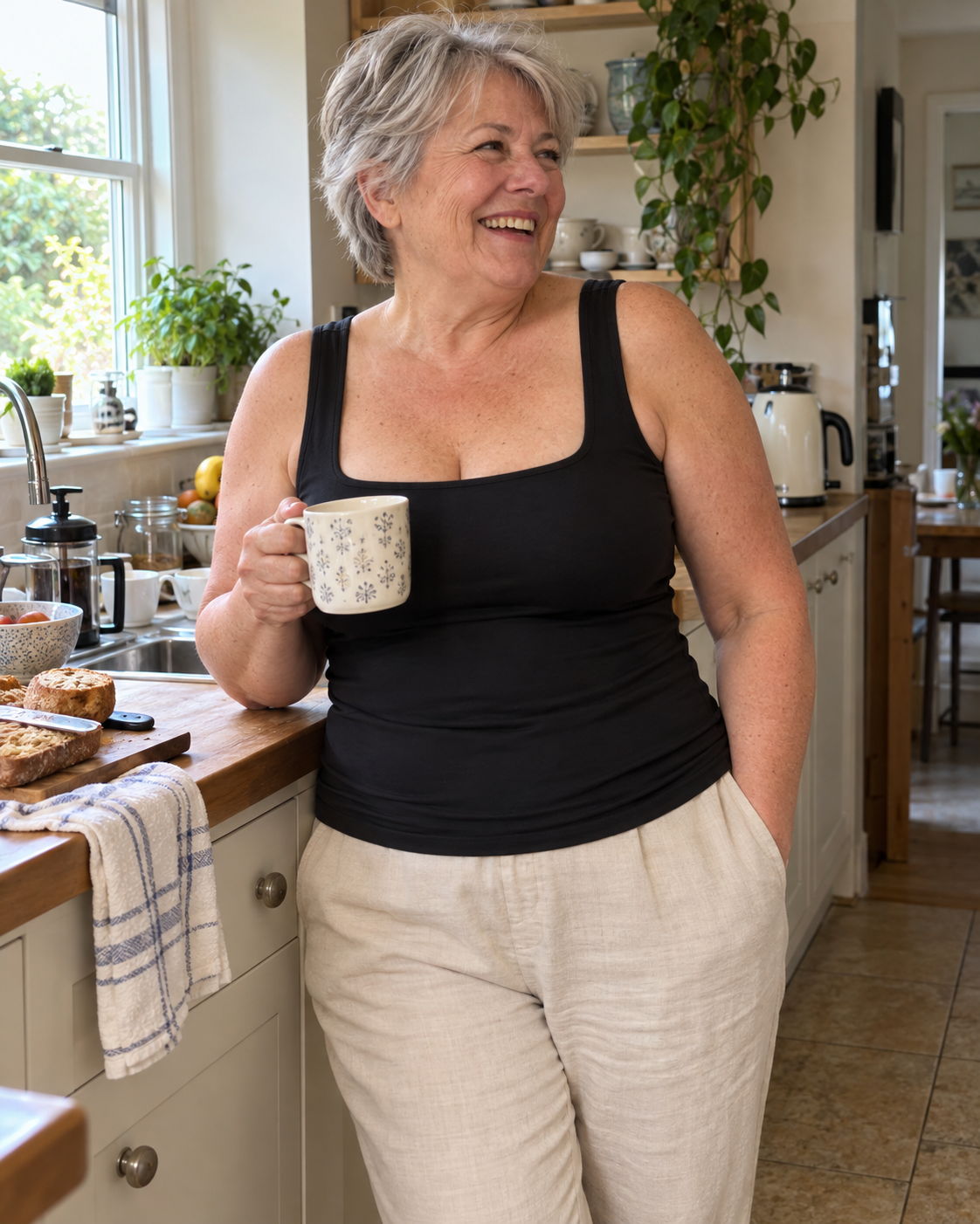 Woman wearing the comfort shaper tank in Black in her kitchen